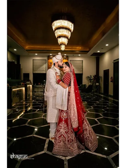 A classic portrait under a grand chandelier. This shot captures the royalty and elegance of the couple on their wedding day.
