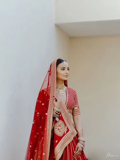 A dreamy, romantic portrait of the bride in her classic red Sabyasachi lehenga. The look is pure elegance.