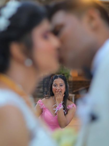 A fun and candid moment where the bridesmaid reacts with shock as the bride and groom share a kiss. Capturing these genuine reactions is a key part of my storytelling.