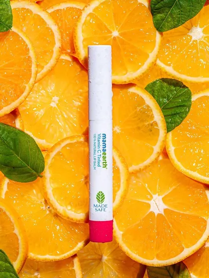 A vibrant and energetic flat-lay created with a bed of fresh orange slices. This "citrus bomb" concept makes the product feel refreshing and full of life, perfect for a vitamin C infused lip balm.