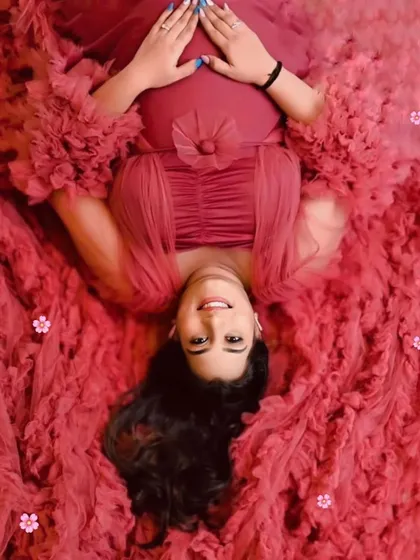 This creative overhead shot showcases the beautiful texture and volume of our wine-red ruffled gown, creating a bed of flowers effect.