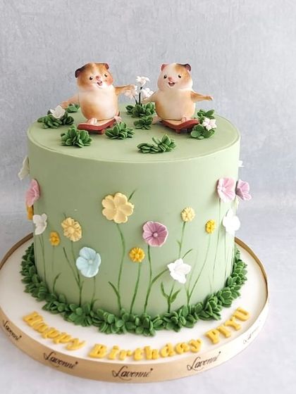 A cute hamster-themed cake for Piyush's birthday. The little fondant hamsters are the stars of this grassy, floral design.