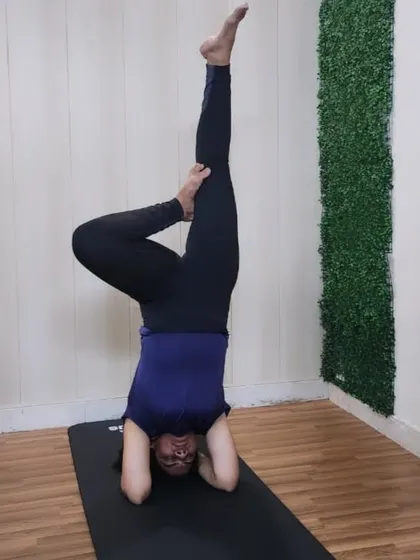 A student holds a variation of Sirsasana (Headstand), showcasing balance and core control in this king of asanas.