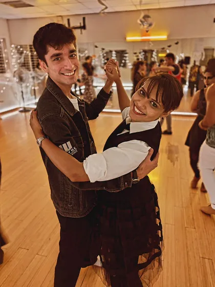 A happy couple posing on the dance floor during our Halloween social. It's a night for costumes, dancing, and making fun memories.