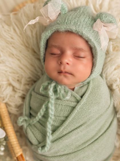 A close-up portrait of a sleeping newborn in a mint green bonnet. Their peaceful expressions are just the sweetest thing to capture.