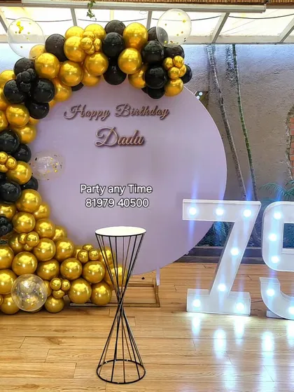 An elegant black and gold setup for a 75th birthday celebration. The large light-up numbers make a bold statement.