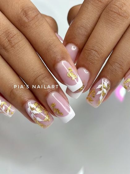 Classic with a twist. A clean French manicure base with white leaf art and gold foil accents for a touch of luxury.