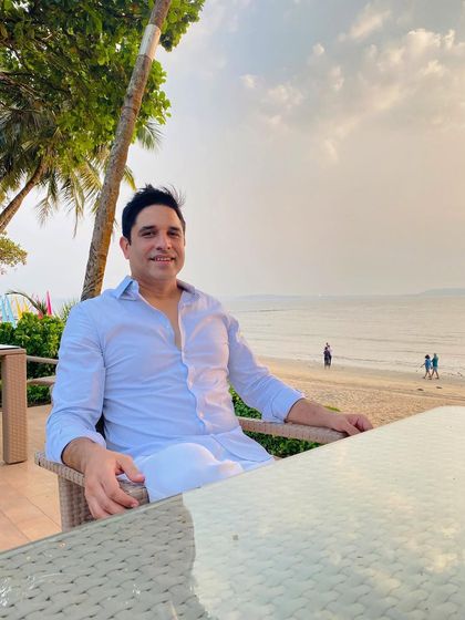 Enjoying the view from a beachside cafe before a wedding event. The sea and the sunset provide a perfect, tranquil setting for a romantic destination wedding.