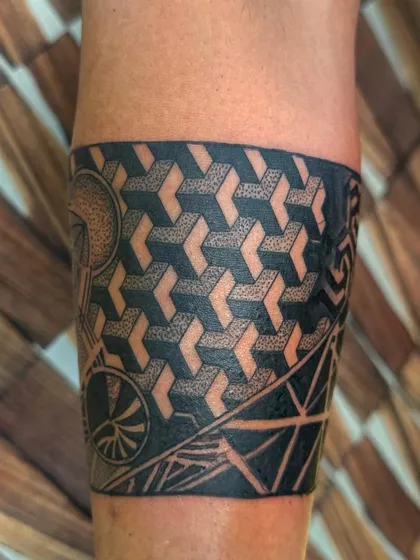 A geometric armband tattoo with a 3D cube pattern. The precise shading creates an optical illusion, making the tattoo look three-dimensional.