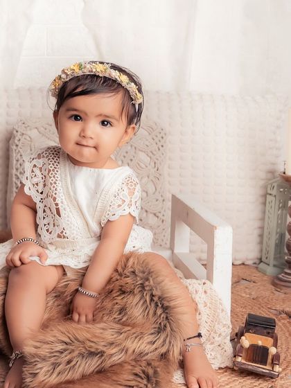 This little girl is stealing my heart, sitting so sweetly on a little white bench. The bohemian decor with candles and a vintage car prop adds a charming, rustic touch.