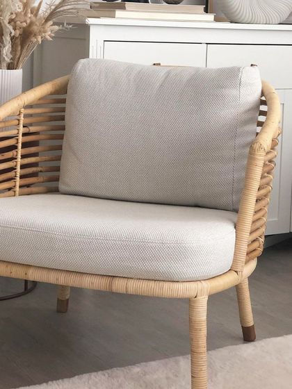 This armchair, shown here with light grey upholstery, is part of a larger set but also works perfectly as a standalone piece for a bedroom or reading nook.