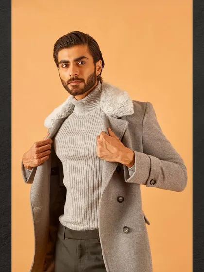 A confident pose in the grey overcoat with the faux fur collar, showcasing a modern and stylish winter ensemble.