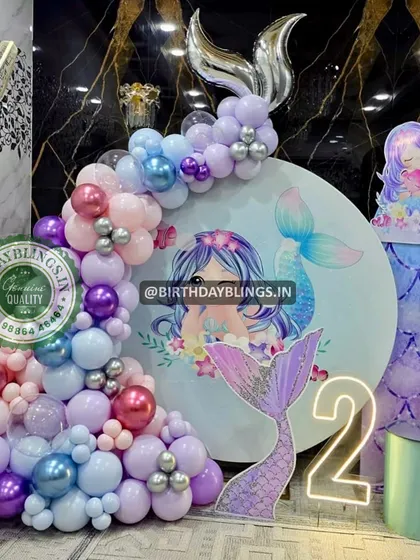 Another detail shot of the glamorous mermaid party, focusing on the mermaid tail cutout and neon sign.