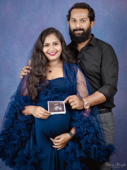 A proud moment for the parents-to-be, holding up their baby's first picture. The sonogram is a powerful symbol of their journey.