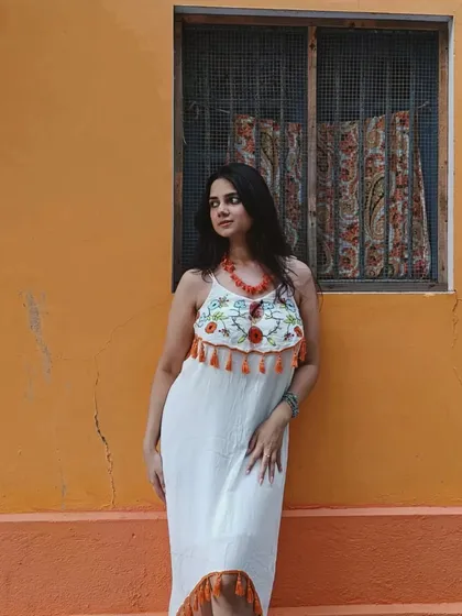 This white embroidered dress with orange tassels was perfect for exploring the colorful French Colony in Pondicherry. The outfit stands out beautifully against the bright orange wall.