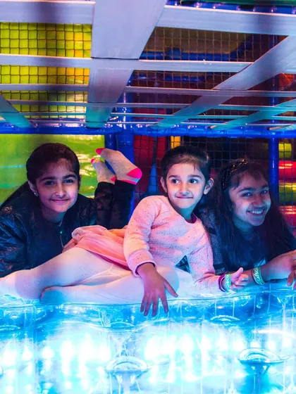 Friends relaxing on the illuminated floor panel after an exciting play session. This sensory feature provides a cool-down spot within the maze.