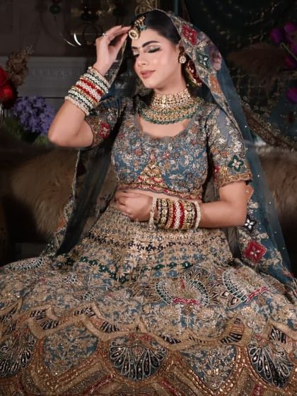 A candid moment of the bride adjusting her tikka. This shot highlights the beautiful jewelry and the flawless makeup.