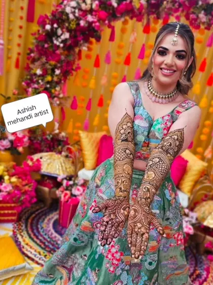 A radiant bride on her mehandi day. I love being part of these happy moments and creating designs that match the joy of the occasion, complete with a vibrant floral backdrop.