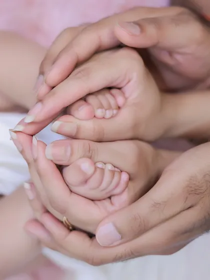 Another beautiful angle of parents' hands cradling their baby's feet. This detailed shot emphasizes just how small and delicate newborns are, a memory you'll want to hold onto.