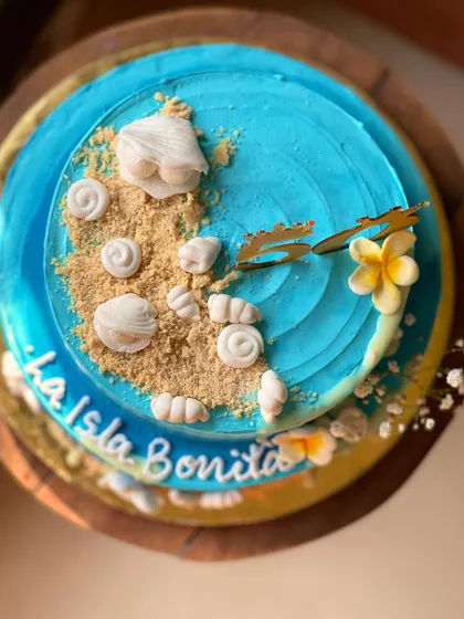 I brought beach vibes to a 50th birthday with this "La Isla Bonita" two-tier cake. The design features buttercream waves, edible sand, and handcrafted shells, showing how I can turn any idea into a delicious reality.