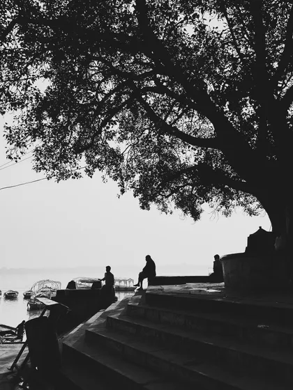 a quiet morning moment on the ghats. this black and white composition focuses on silhouette and form, stripping away distraction to focus on the essential subjects.