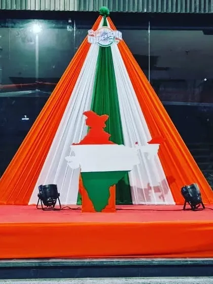 A custom stage setup for a Republic Day event, featuring a podium shaped like the map of India against a backdrop of tricolor drapes.