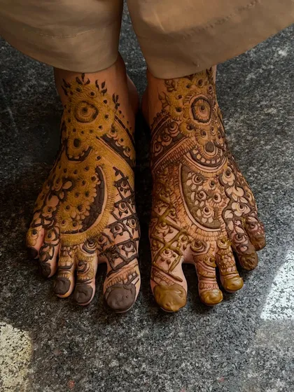 This Pakistani-style foot mehendi features large, prominent circular motifs, filled with delicate patterns. It's a classic look for a bride.