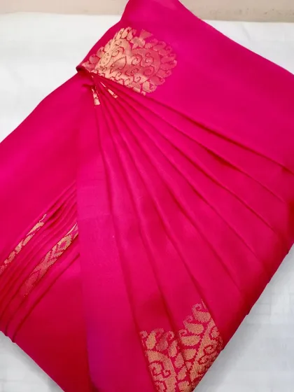 This bright pink silk saree is pleated and ready to be draped.