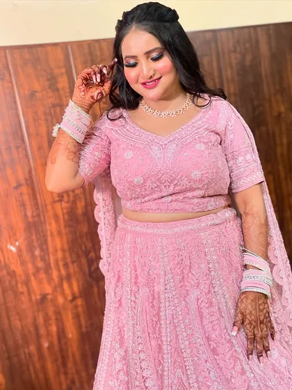 A happy and confident bride-to-be. Her pink lehenga and soft glam makeup create a perfect engagement look.