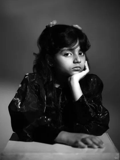 Even our youngest subjects have profound stories to tell. This black and white portrait from a child's portfolio session focuses on capturing a moment of quiet thought and natural expression, showing a maturity beyond her years.