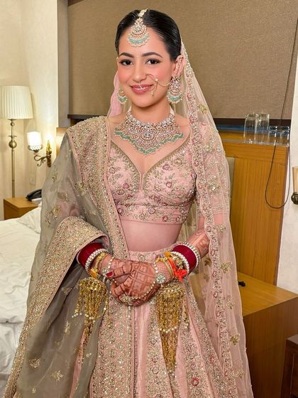 The final look, complete with a traditional nath and a sheer dupatta. The bride looks happy, comfortable, and absolutely beautiful.