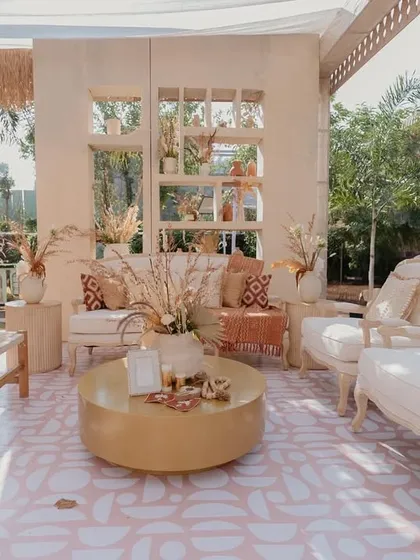 A beautifully styled lounge area with a mix of classic and rustic furniture. The gold coffee table adds a touch of glamour to the otherwise earthy and neutral palette.