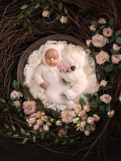 A fine art portrait of a sleeping baby, nestled in a floral wreath. This image showcases the artistic and delicate side of newborn photography, where I use creative setups to turn a simple portrait into a piece of art you will cherish forever.