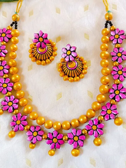 A bright pink version of the floral and golden bead necklace. This piece is perfect for mehendi or sangeet functions, adding a pop of vibrant color.