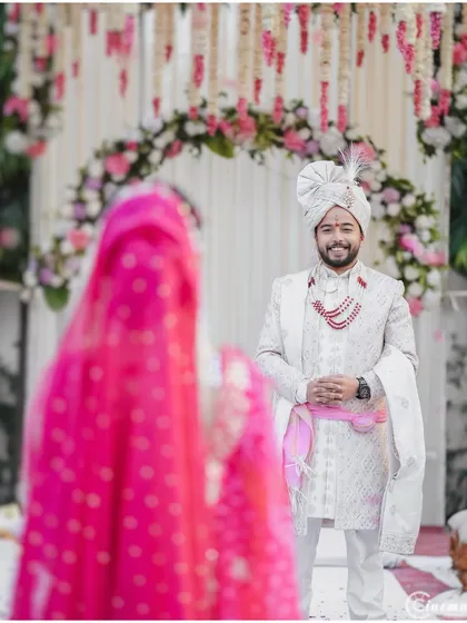 The groom's smiling face as he sees his bride approaching. Capturing both perspectives of the first look is key to telling the whole story.