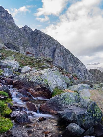 A small stream cascades over rocks in the mountains of Himachal Pradesh. This image captures a piece of the raw, untamed beauty of the Himalayas.