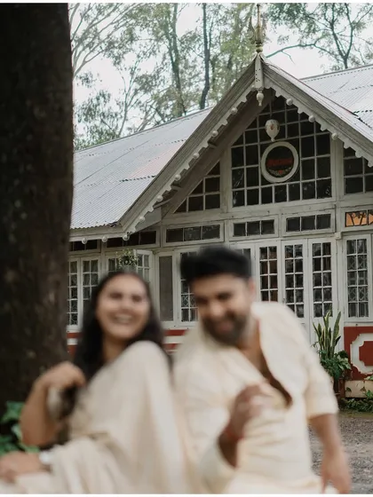 A blurry, dreamlike shot of the couple in front of a heritage building, capturing a moment of pure, uninhibited joy.