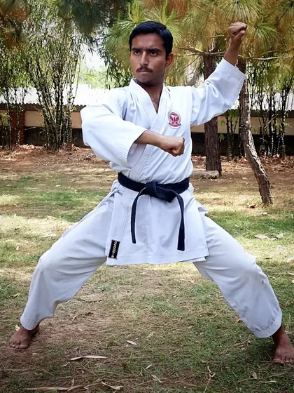 Holding a strong Kiba-dachi (horse stance) while executing a block. A solid stance is the foundation of all power in karate.