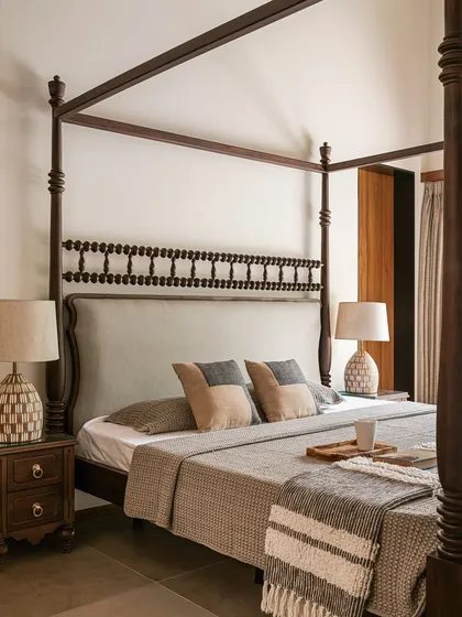 These bespoke wardrobes blend a soft, powdery grey with warm oak. The oversized circular wooden pulls act as modern Kolam-inspired strokes, adding a graphic and tactile detail to the minimalist design.