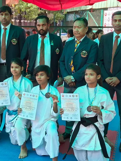 Our young champions with officials at the district championship. We teach respect and sportsmanship alongside technique.