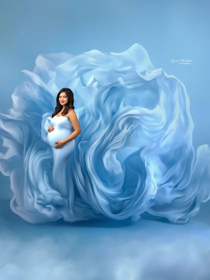 This shot is all about creating art with fabric. The swirling blue material envelops the mother-to-be, creating a dynamic and abstract portrait that feels like a wave of beautiful emotion.