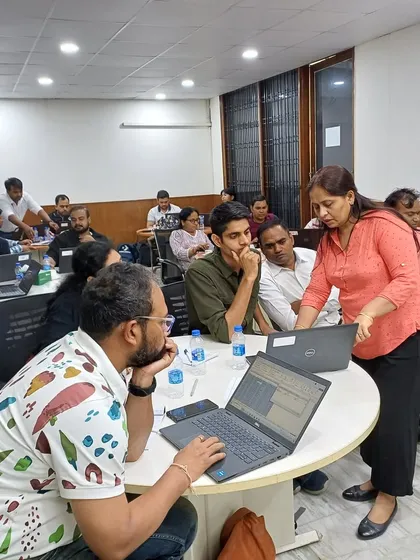 Personalized Coaching During a Group Workshop. I make it a point to connect with small groups during my training sessions. Here, I'm helping a team navigate a challenging Excel problem, ensuring no one is left behind.