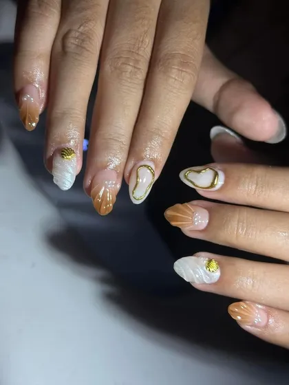 A closer look at the seashell-inspired nail art, showing the texture and gold details. These are the kind of details that make a design stand out.
