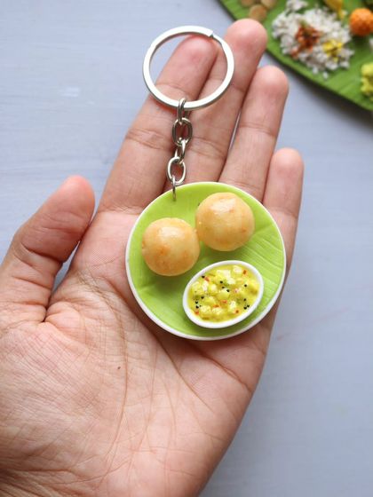 A tiny poori with bhaji keychain, a cute and portable piece of food art.