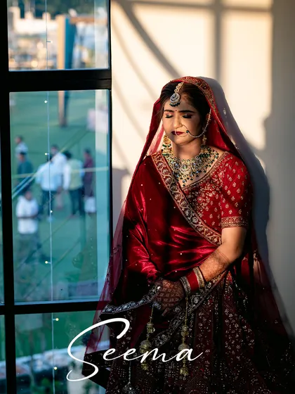 A serene bridal portrait by the window. The natural light and shadows create a beautiful, contemplative mood, highlighting the bride's elegance.