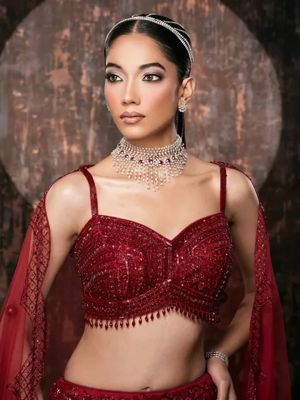 A modern interpretation of couture glamour. This image balances a striking pose with intricate details, from the beaded crimson top to the diamond choker. Our lighting is sculpted to highlight both the flawless makeup and the luxurious textures of the ensemble.