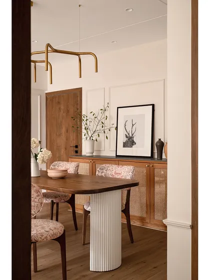 A view of the dining area in our Bandra project, "Apartment 222." The custom wooden table with a fluted cement base is paired with paisley-upholstered chairs, blending natural textures with refined patterns for a warm, minimalist feel.