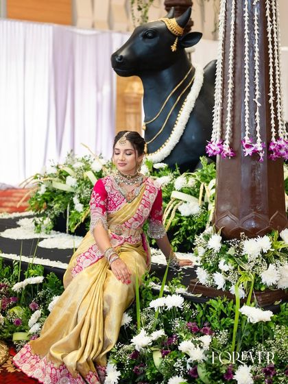 A full-length shot showing the client in a traditional setting, her golden Kanjivaram saree shimmering.