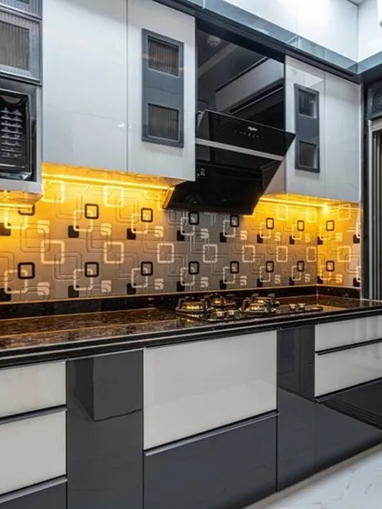 A kitchen designed with a bold, graphic backsplash and two-tone cabinets in grey and white. The layout includes space for a built-in microwave and oven, showcasing our expertise in appliance integration.