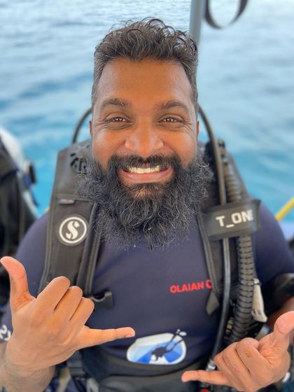 The classic 'shaka' sign from a happy diver. It's the universal symbol for 'hang loose' and perfectly captures the vibe of our dive trips.